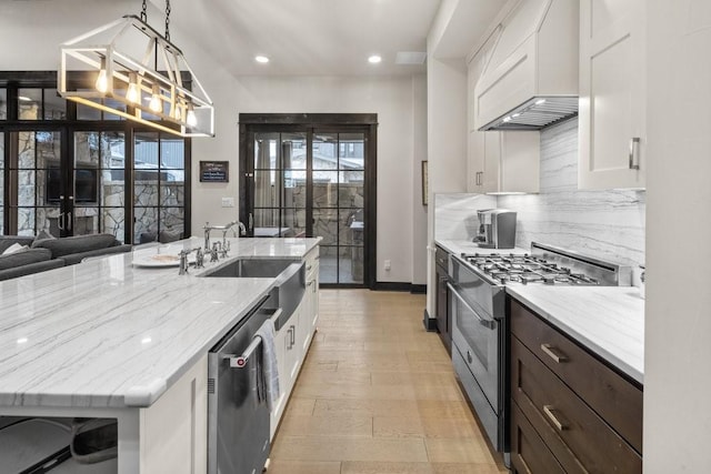 kitchen with appliances with stainless steel finishes, pendant lighting, white cabinetry, custom exhaust hood, and light stone countertops