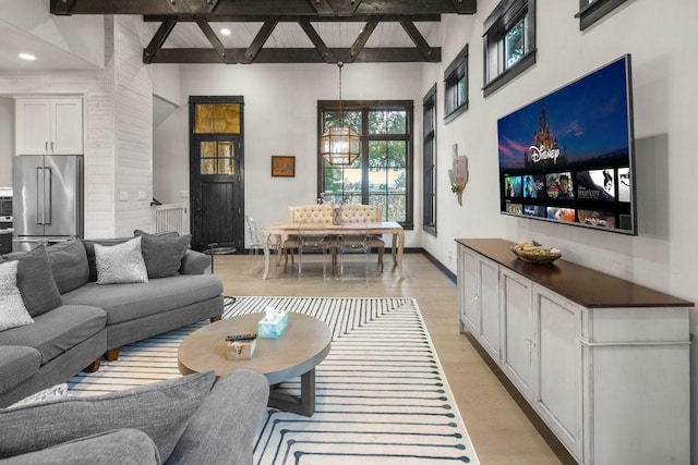 living room featuring beamed ceiling and light wood-type flooring