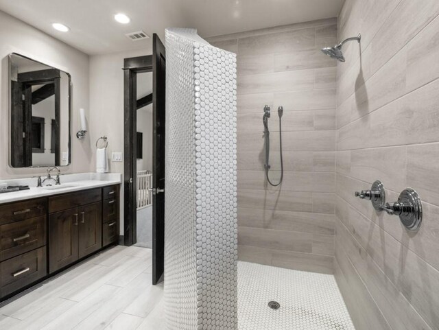 bathroom with vanity and tiled shower