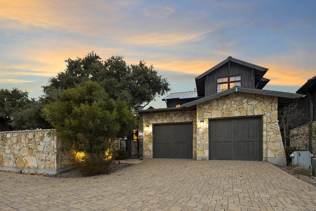 view of front of property with a standing seam roof, metal roof, board and batten siding, and driveway