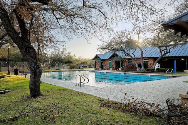 view of swimming pool featuring a patio area and a lawn