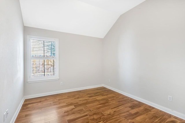 empty room featuring lofted ceiling and hardwood / wood-style floors