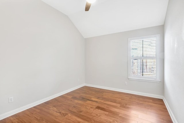 empty room featuring hardwood / wood-style floors, vaulted ceiling, and ceiling fan