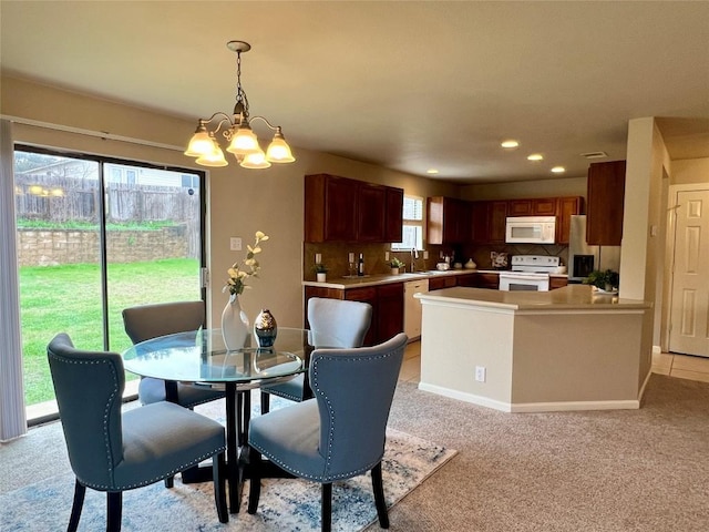 dining room with light colored carpet, sink, and a notable chandelier