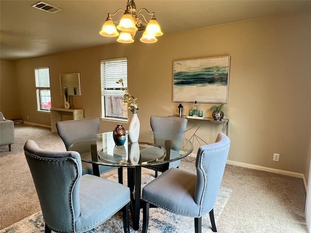 dining space with a notable chandelier and light colored carpet