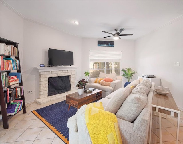 tiled living room featuring ornamental molding, a stone fireplace, and ceiling fan