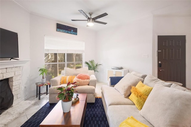 living room with a stone fireplace, ornamental molding, and ceiling fan