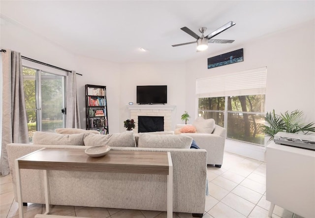 tiled living room with ceiling fan and a fireplace