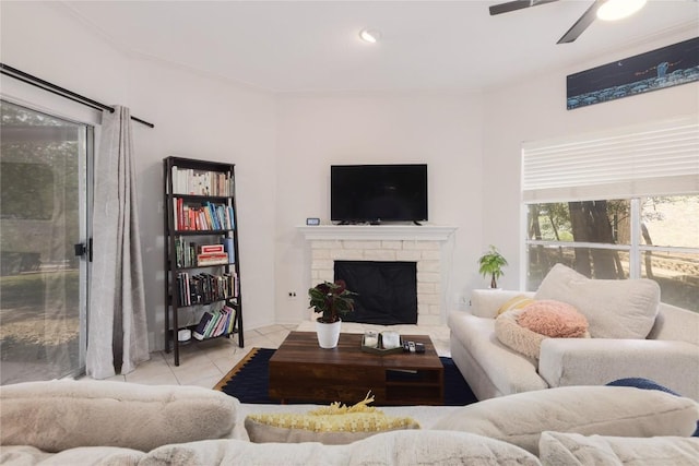 tiled living room with ceiling fan and a fireplace