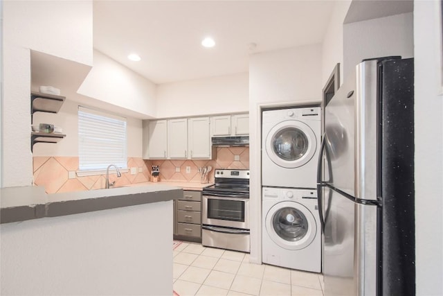 kitchen featuring light tile patterned flooring, sink, stacked washer / dryer, stainless steel appliances, and backsplash