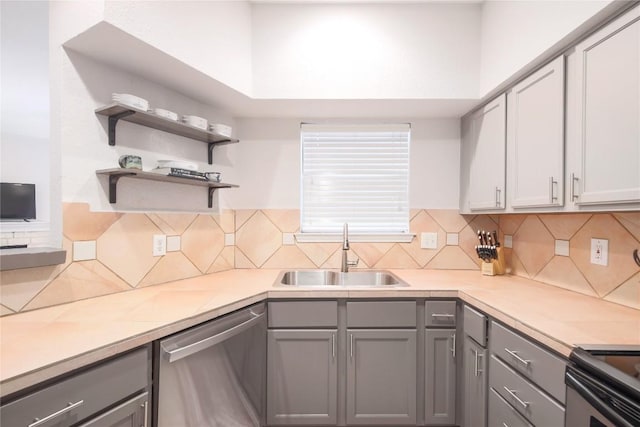 2450 Wickersham Ln Unit M1311, Austin, TX 78741 - kitchen with stainless steel dishwasher, gray cabinetry, a sink, and backsplash