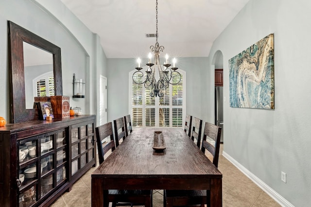 tiled dining room with an inviting chandelier and vaulted ceiling