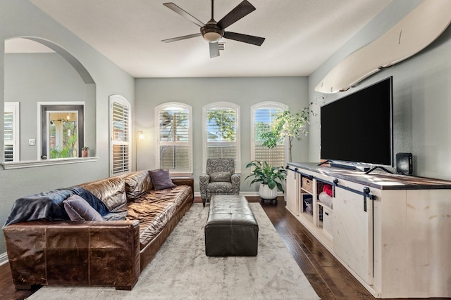 living room featuring dark wood-type flooring and ceiling fan