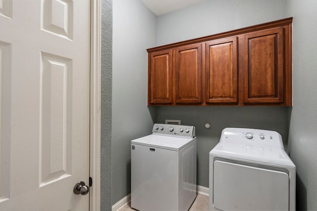 laundry room with independent washer and dryer and cabinets