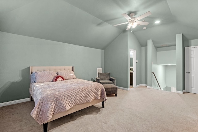 carpeted bedroom featuring ceiling fan, lofted ceiling, and ensuite bath