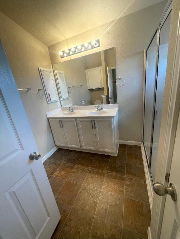 bathroom featuring vanity and a shower with door