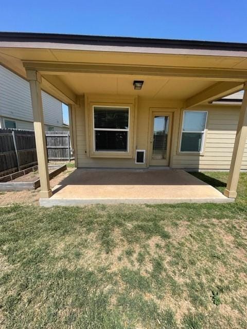 back of house with a yard and a patio