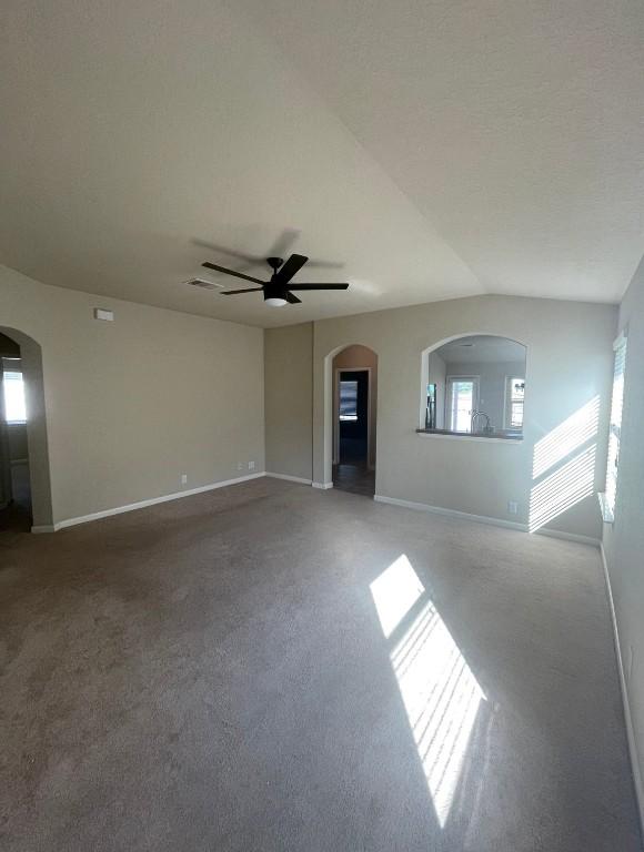 unfurnished living room featuring carpet flooring, a wealth of natural light, and ceiling fan