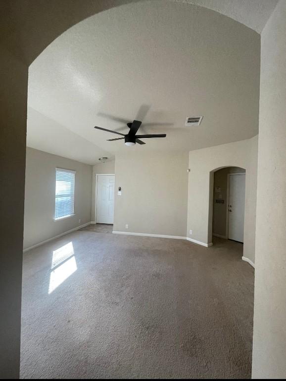 empty room featuring ceiling fan, carpet floors, and a textured ceiling