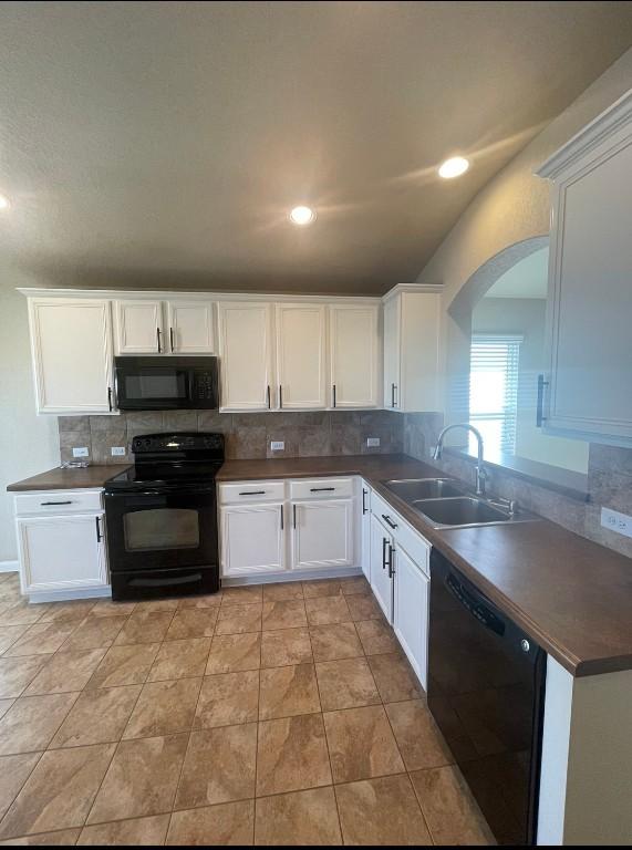 kitchen featuring white cabinetry, sink, tasteful backsplash, and black appliances