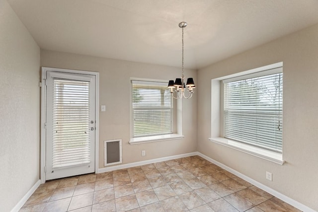 unfurnished dining area featuring baseboards, light tile patterned floors, and a notable chandelier