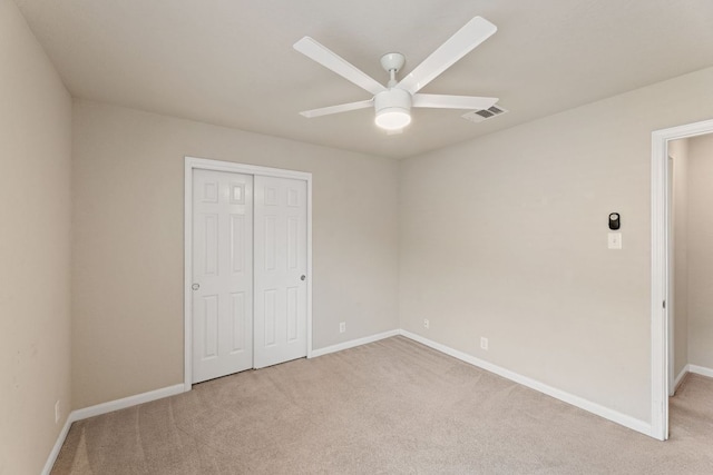 unfurnished bedroom with baseboards, visible vents, a closet, and light colored carpet