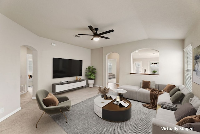 living area featuring carpet floors, arched walkways, visible vents, and ceiling fan