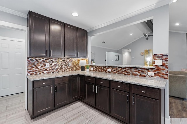 kitchen featuring dark brown cabinetry, decorative backsplash, and kitchen peninsula