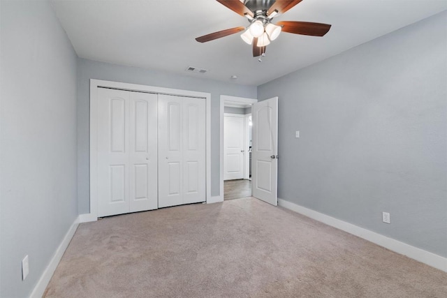 unfurnished bedroom featuring light colored carpet, ceiling fan, and a closet