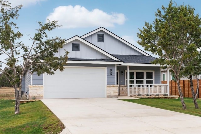 view of front of home with a garage, a porch, and a front yard