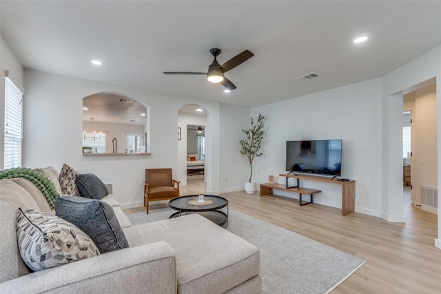 living room with light hardwood / wood-style flooring and ceiling fan