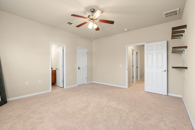 unfurnished bedroom featuring connected bathroom, light colored carpet, and ceiling fan