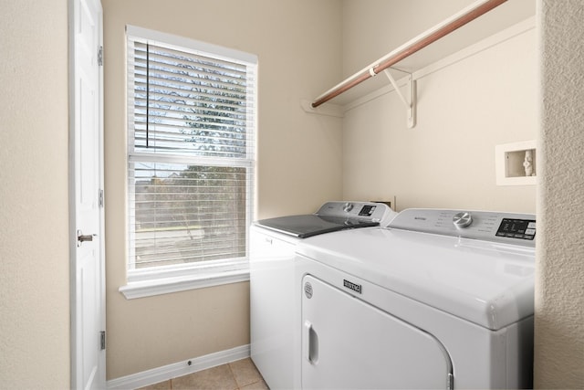 washroom with separate washer and dryer and light tile patterned floors