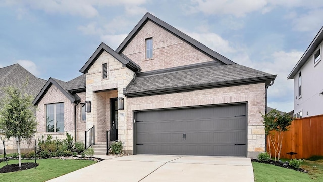 667 Bay Breeze Dr, Kyle, TX 78640 - french country home with stone siding, concrete driveway, and a shingled roof