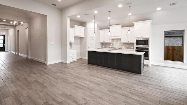 667 Bay Breeze Dr, Kyle, TX 78640 - kitchen featuring appliances with stainless steel finishes, light wood-style floors, light countertops, white cabinets, and recessed lighting
