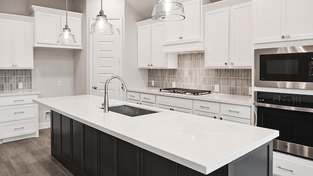 667 Bay Breeze Dr, Kyle, TX 78640 - kitchen featuring stainless steel appliances, tasteful backsplash, white cabinetry, light countertops, and hanging light fixtures