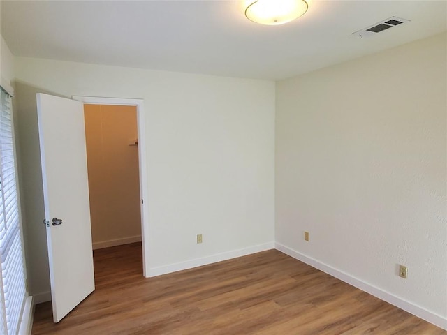 spare room featuring baseboards, visible vents, and light wood finished floors