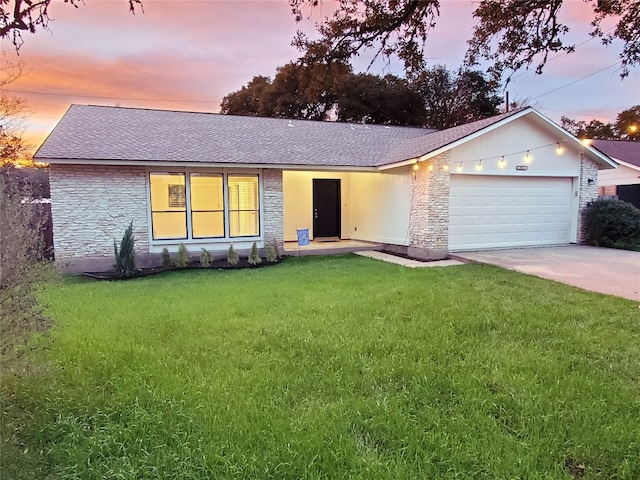 ranch-style home featuring stone siding, a front lawn, concrete driveway, and an attached garage