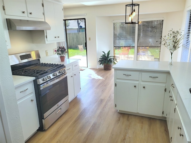 kitchen featuring stainless steel gas range oven, light wood-style flooring, white cabinetry, light countertops, and extractor fan