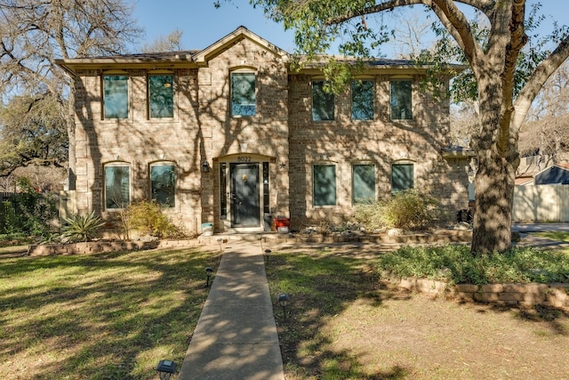 colonial-style house featuring a front yard