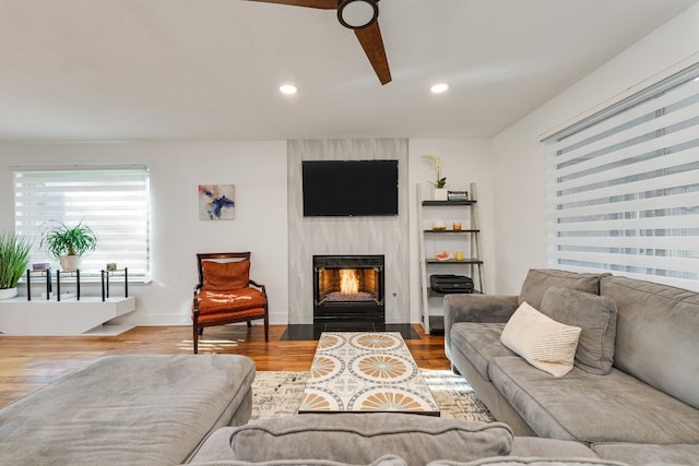 living room with wood-type flooring and a large fireplace