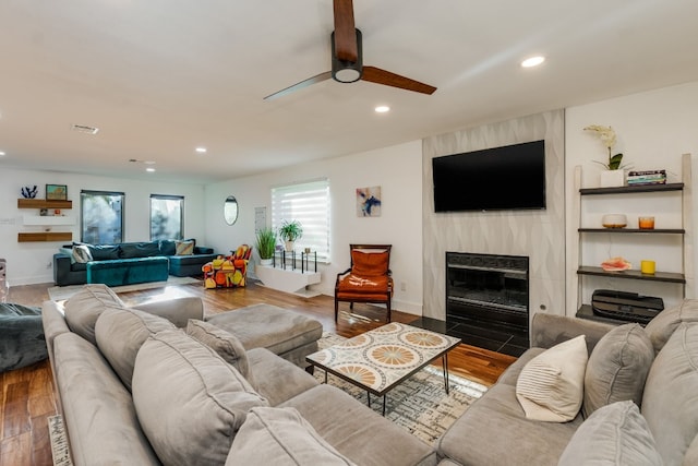 living room featuring hardwood / wood-style flooring, a fireplace, and ceiling fan