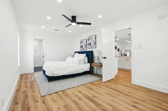 bedroom featuring ensuite bath, light hardwood / wood-style flooring, and ceiling fan