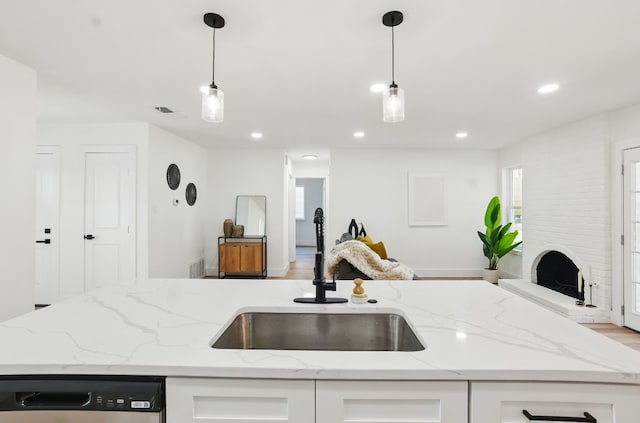 kitchen with white cabinetry, sink, and decorative light fixtures