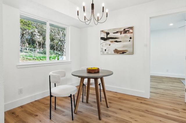 dining space with a chandelier and light hardwood / wood-style flooring