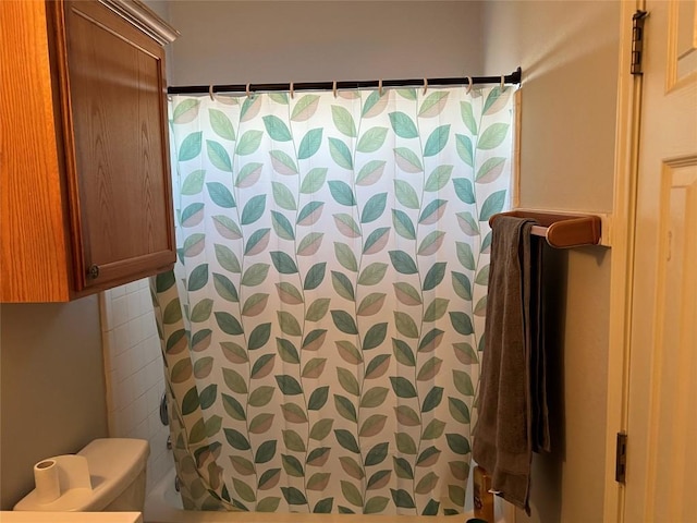 bathroom featuring tasteful backsplash, toilet, and a shower with shower curtain