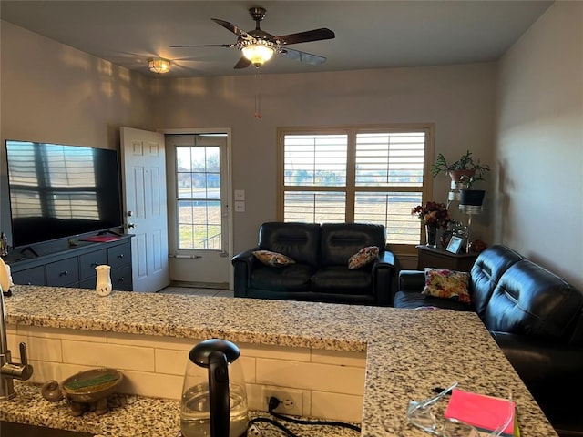 living room featuring ceiling fan and a wealth of natural light