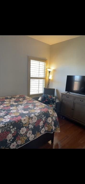 bedroom with dark hardwood / wood-style floors