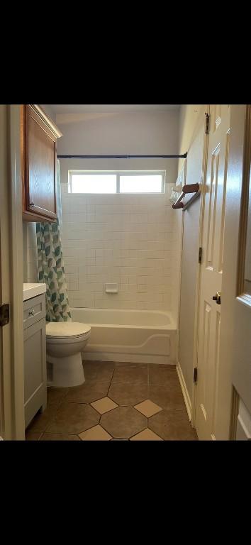 bathroom featuring toilet, tile patterned flooring, and shower / bath combo with shower curtain