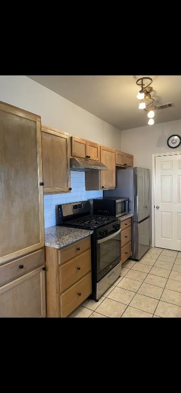 kitchen with stainless steel appliances and light tile patterned floors